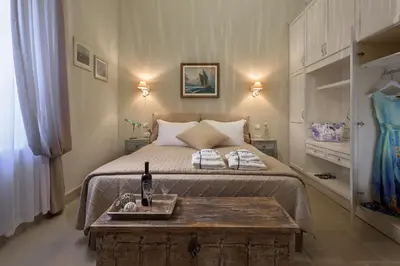 a bedroom with a large bed with a wooden table at Admiral's House in Halki