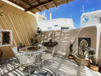 a patio with a table and chairs on a balcony at Rose traditional house in Archangelos