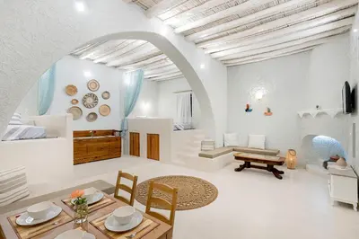 a living room with a table and a dining room at Rose traditional house in Archangelos
