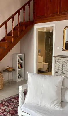 a living room with a white couch and a staircase at Villa Hiona-Seafront Villa in Halki