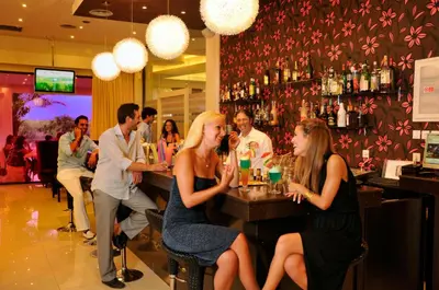 a group of people sitting at a bar at Afandou Bay Resort Suites in Afantou