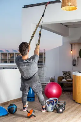 a man hanging from a ceiling with a rope at Euphoria Luxury apartment in Faliraki