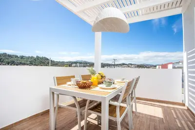 a white dining table and chairs on a balcony at Euphoria Luxury apartment in Faliraki
