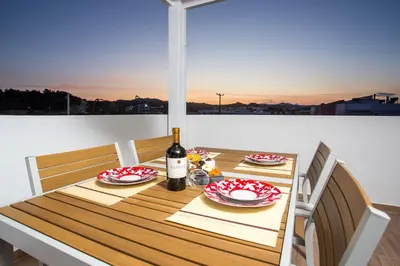 a table with a bottle of wine sitting on a balcony at Euphoria Luxury apartment in Faliraki