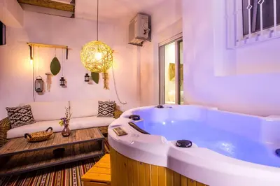 a large bath tub in a room with a couch at Euphoria Luxury apartment in Faliraki