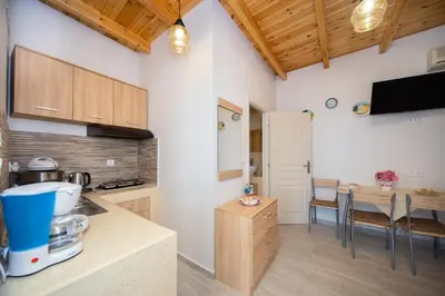 a kitchen with wooden cabinets and a table with chairs at Vista Mare in Archangelos