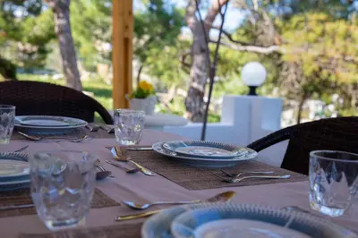 a table with plates and glasses on top of it at Vista Mare in Archangelos