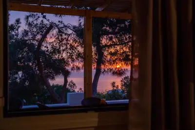 a window with a view of a sunset at Vista Mare in Archangelos