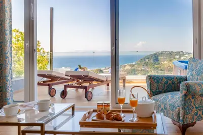 a living room with a view of the ocean at FlyViewFlatsBLUE PrivateHotTub with SeaView in Rhodes Town