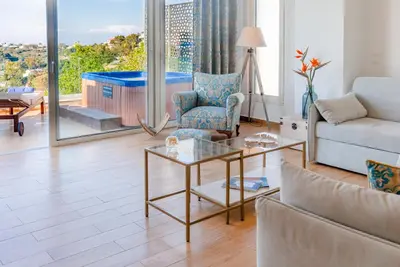 a living room with a couch and a table at FlyViewFlatsBLUE PrivateHotTub with SeaView in Rhodes Town