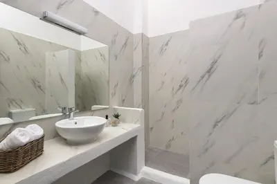 a white bathroom with a sink and a mirror at Mea Terra Villas in Lachania