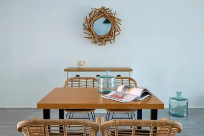 a dining room table with chairs and a mirror at Mea Terra Villas in Lachania