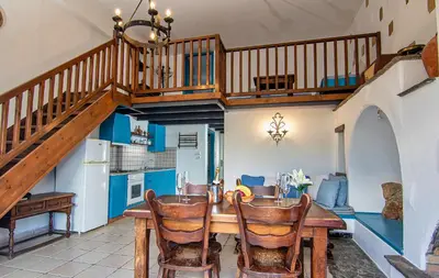 a kitchen and dining room with a wooden table and stairs at Nostalgia Suites in Faliraki