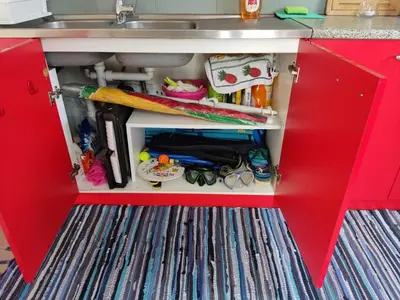 a red kitchen cabinet with a sink and tools at Park House -beside the Medieval Town of Rhodes-free parking in Rhodes Town