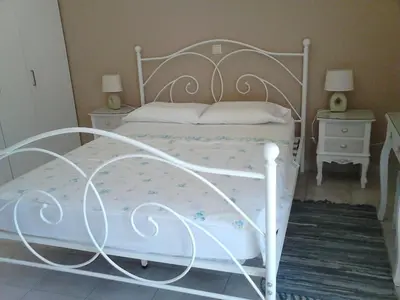 a white bed in a bedroom with two night stands at Park House -beside the Medieval Town of Rhodes-free parking in Rhodes Town