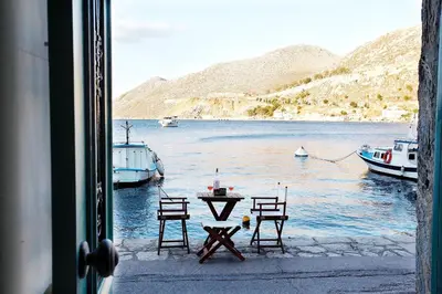 a view of a table and chairs from a window at SeaMe Houses in Symi