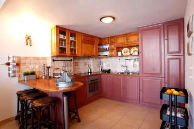 a kitchen with red cabinets and a wooden island at SeaMe Houses in Symi