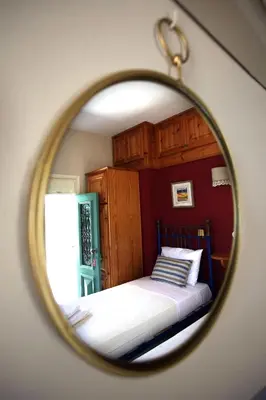 a mirror reflection of a bed in a bedroom at SeaMe Houses in Symi