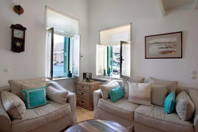 a living room with two couches and two windows at SeaMe Houses in Symi
