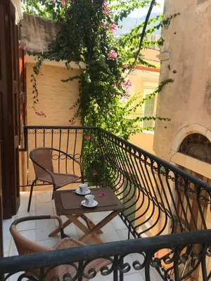 a balcony with a table and chairs and flowers at The one & only in Symi
