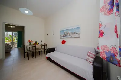 a living room with a white couch and a table at Sunset Apartments in Archangelos