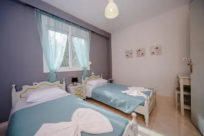 a bedroom with two beds and a window at Sunset Apartments in Archangelos
