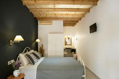 a bedroom with a bed with a wooden ceiling at Sunset Apartments in Archangelos