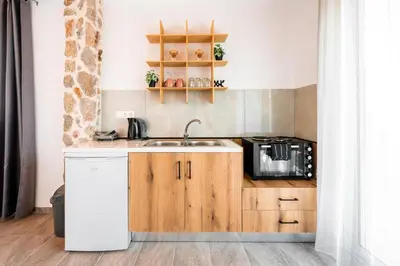 a kitchen with a sink and a microwave at Sunset Apartments in Archangelos
