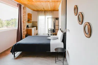 a bedroom with a bed and a door leading to a kitchen at Sunset Apartments in Archangelos