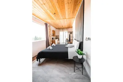a bedroom with a bed and a wooden ceiling at Sunset Apartments in Archangelos