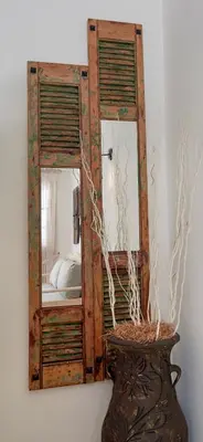 a mirror on a wall next to a vase at Iapetos Village in Symi