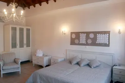 a bedroom with a white bed and a chandelier at Iapetos Village in Symi
