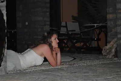 a young woman in a white dress laying on the floor at Iapetos Village in Symi