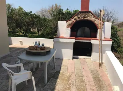 a patio with a table and a pizza oven at Villa George in Apolakkiá