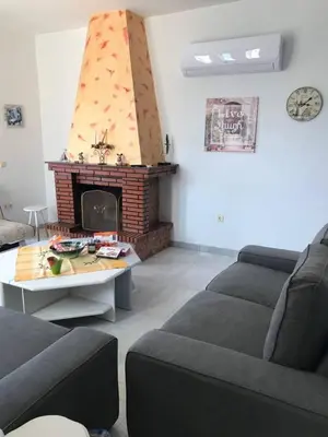 a living room with a couch and a fireplace at Villa George in Apolakkiá