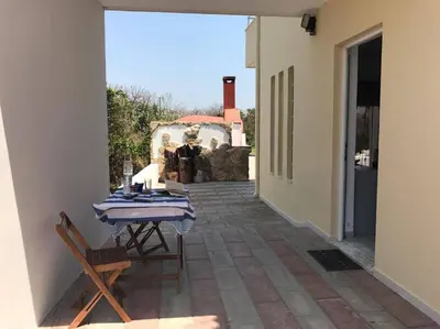 a patio with a table and chairs and a building at Villa George in Apolakkiá