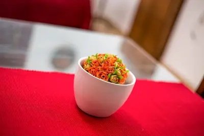 a small white bowl of food on a red table at CasaLindos Festa in Líndos