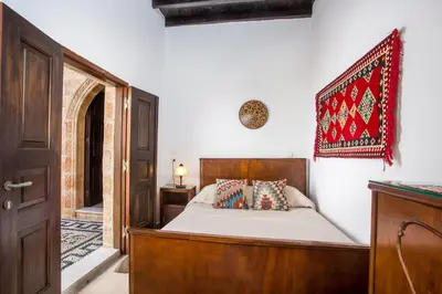 a bedroom with a bed and a rug on the wall at CasaLindos Festa in Líndos