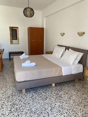 a bedroom with a large bed with towels on it at Sarris Studios & Apartments in Líndos