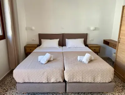 a bedroom with two beds with white pillows on them at Sarris Studios & Apartments in Líndos