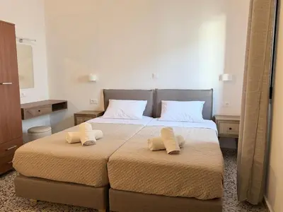 a bedroom with two beds with white towels on them at Sarris Studios & Apartments in Líndos