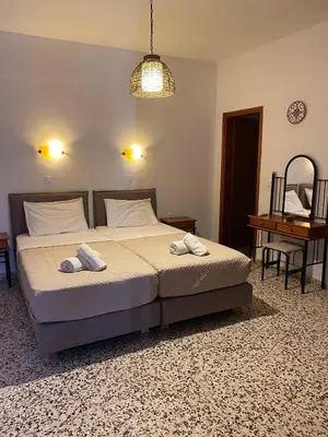 a bedroom with a bed with two towels on it at Sarris Studios & Apartments in Líndos