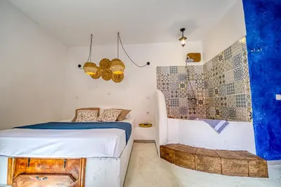 a bedroom with a bed and a shower at Mascot Garden Rooms in Rhodes Town