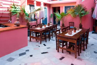 a restaurant with wooden tables and chairs on a patio at Mascot Garden Rooms in Rhodes Town