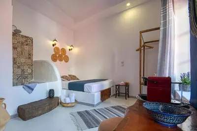a bedroom with a bed and a couch in a room at Mascot Garden Rooms in Rhodes Town