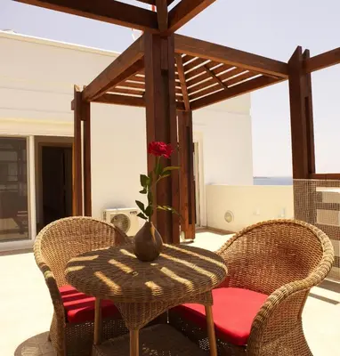 a table with two chairs and a vase on it at Villa Kivotos in Lardos