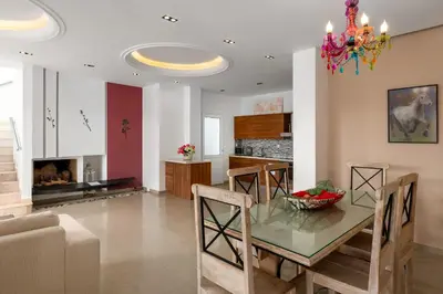 a dining room and kitchen with a table and chairs at Villa Kivotos in Lardos