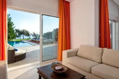 a living room with a couch and a large window at Villa Kivotos in Lardos