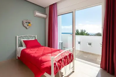 a bedroom with a bed and a large window at Villa Kivotos in Lardos