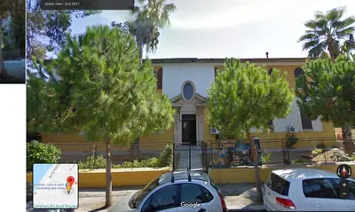 a white car parked in front of a yellow building at Romantic rooms with stunning sea view in Rhodes Town